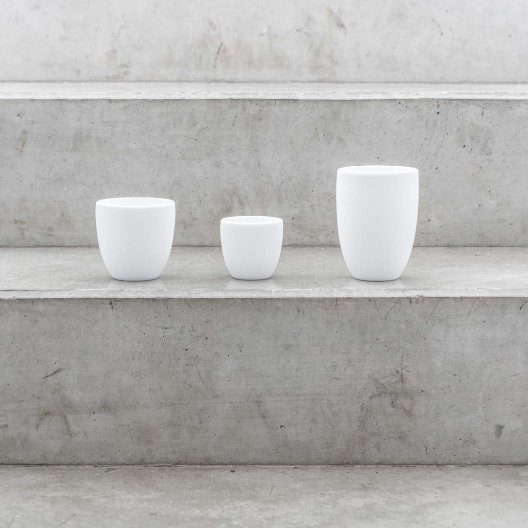 Drei weiße Kaffeetassen auf grauen Marmor Treppen